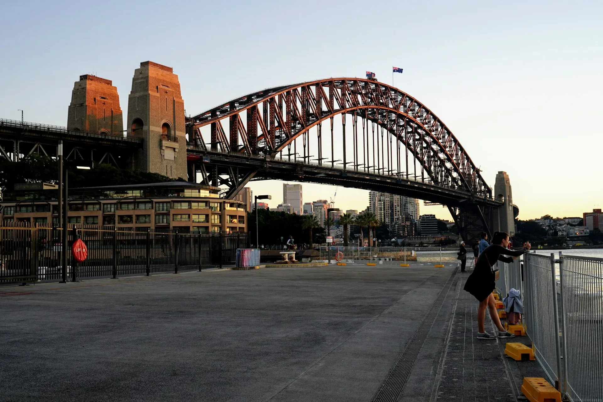 people on walkway under large bridge