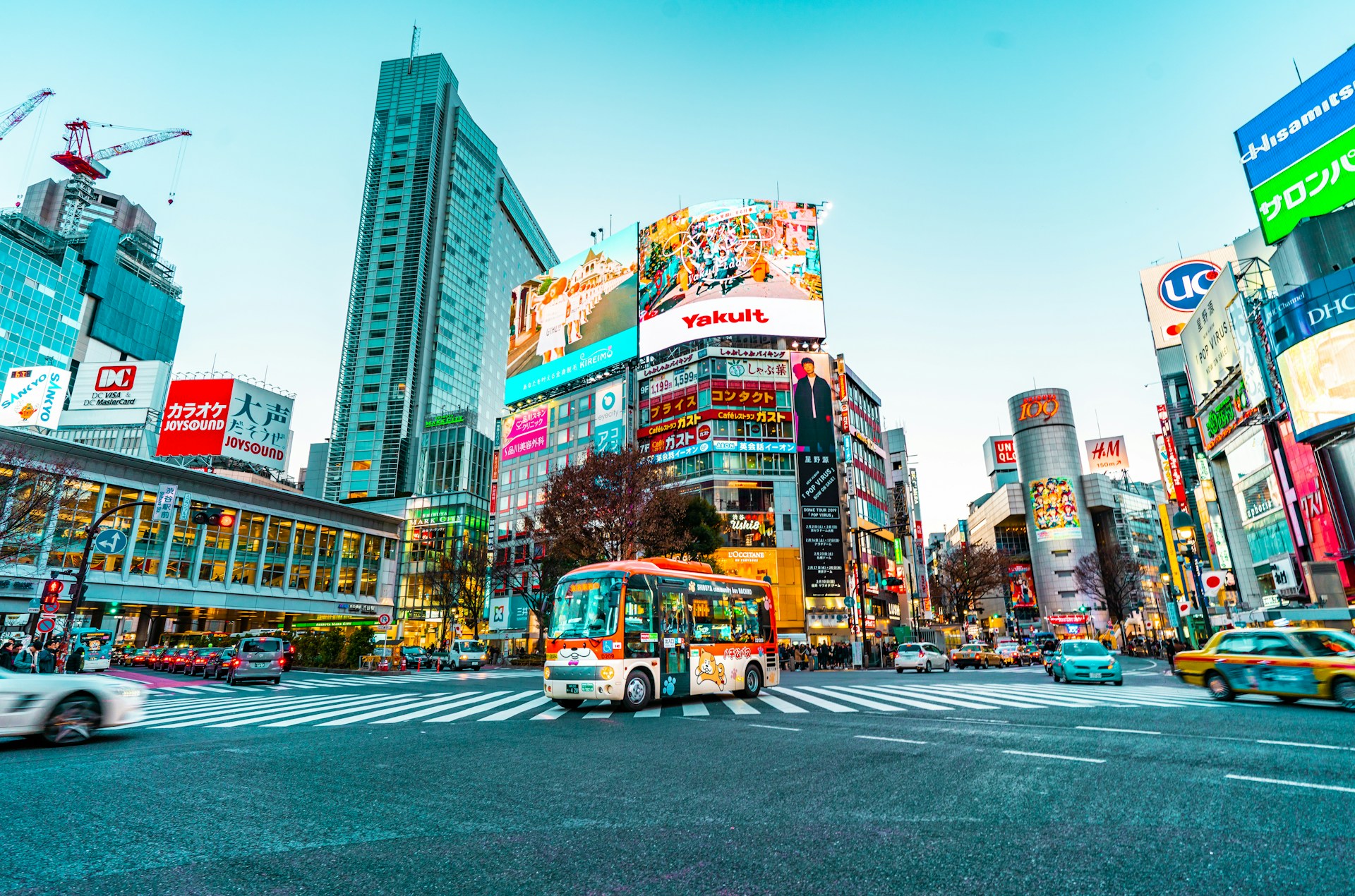 A bus at the centre of a street crossing in Shibuya, Japan